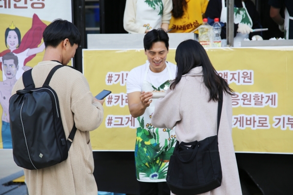 개그맨 김재우가 '카레한상' 행사에서 시민들에게 카레를 전달하고 있다 (사진제공/밀알복지재단)